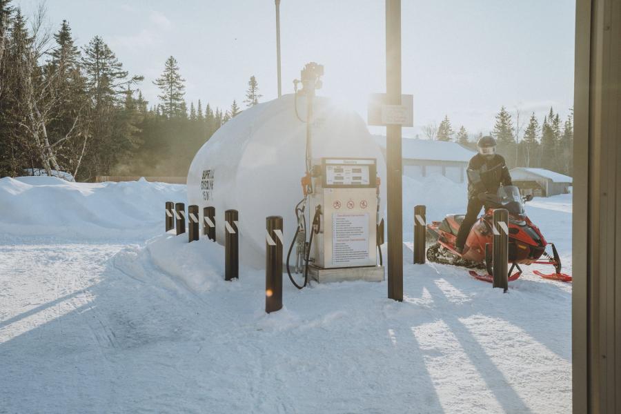 a man at a snowmobile fuelling station