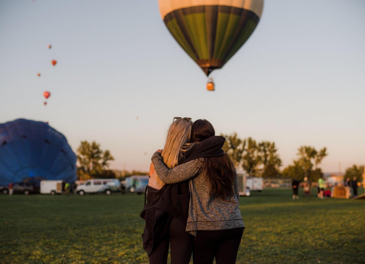 two people looking at hot air balloon taking off